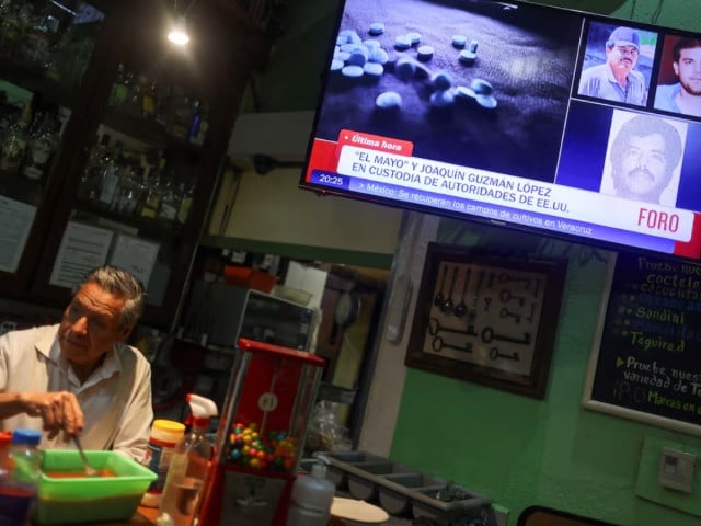 a barman stands next to a tv showing the news of the arrest of mexican drug lord ismael el mayo zambada and the son of his former partner joaquin el chapo guzman at a private airport in el paso texas at a cantina in mexico city mexico july 25 2024 photo reuters